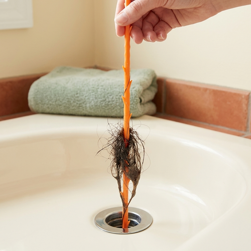 Pulling a hair clog out of a bathtub drain with the Ezzily drain snake